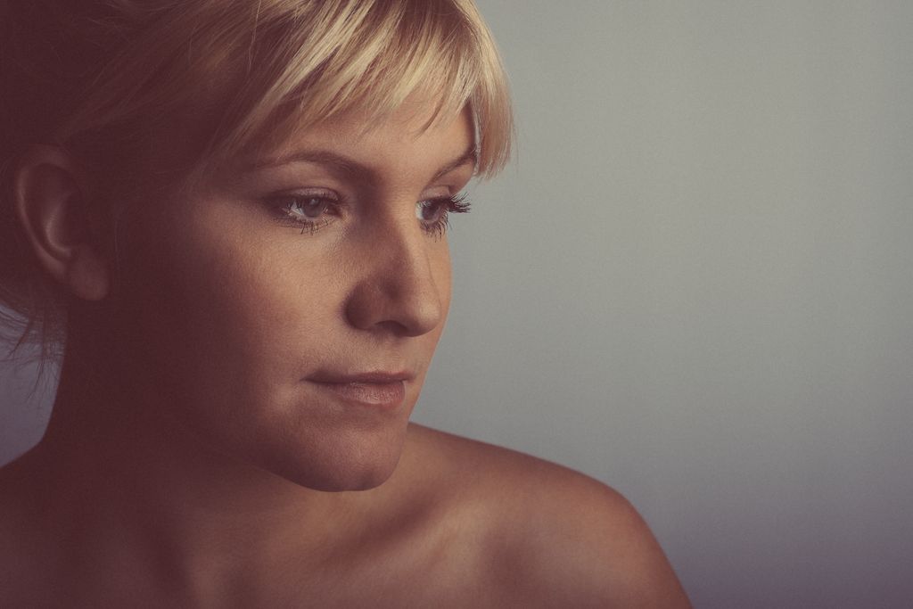 Cinematic profile portrait photography with moody lighting featuring blonde woman