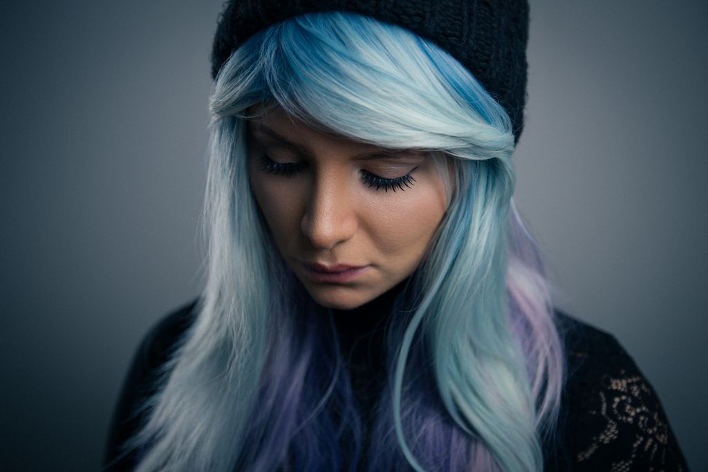 Moody studio portrait photography by Thor Visuals featuring woman with blue hair and beanie